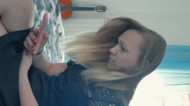 dikey video. Kız telefona bakar..