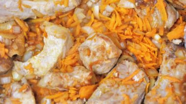 Kızarmış et parçalarını havuç ve soğanla yakın plan çek..