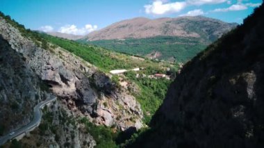 Güneşli Abruzzo 'da dağların ve yeşilliklerin ortasındaki çıplak bir vadi etrafındaki hava manzarası. İtalya İHA atışının etrafında dönüyor.