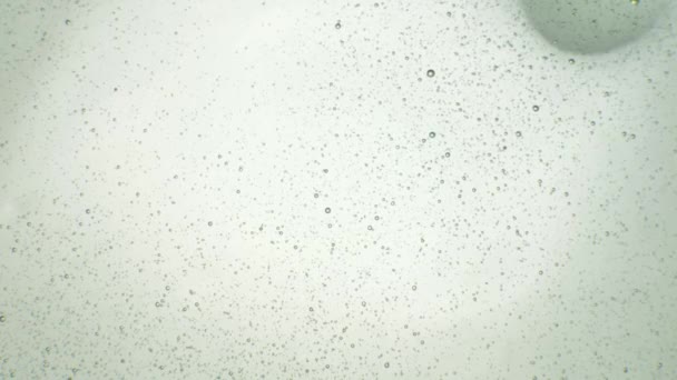 透明的液体散布在白色的背景上 透明的宇宙液体 带气泡的凝胶质感 液体提取 抽象的自然艺术 — 图库视频影像