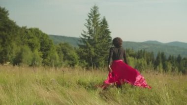 Neşeli heyecanlı Afro-Amerikan kadın gezgin eğlence ve manzaralı dağ doğasının tadını çıkarıyor.