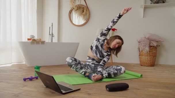 Heerlijk sportieve fitness vrouw oefenen zittende side bend stretch yoga oefening online klasse — Stockvideo