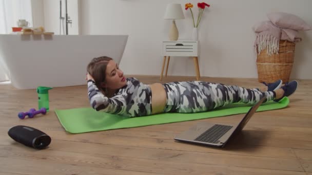 Behoorlijk actieve fit vrouw doen fiets crunch workout te verbeteren buikspieren tijdens online yoga klasse — Stockvideo