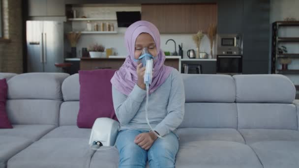 Krásná nemocná islámské školního věku dívka nosí masku nebulizátor, inhalační pára sprej léky uvnitř — Stock video