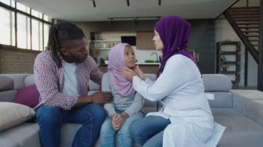 Olumlu tesettürlü kadın hekim hasta, şirin, Afro-Amerikan kızı içeri tıkıyor.