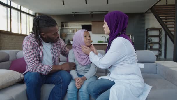 Positiv hijab kvinnlig läkare auskulterande sjuk söt muslimsk afrikansk amerikansk flicka inomhus — Stockvideo