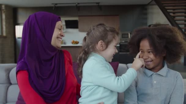 Despreocupado bastante hijab árabe madre divirtiéndose con dos hijas pequeñas multirraciales en casa — Vídeos de Stock