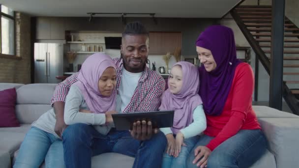 Familia musulmana multiétnica unida con dos hijas adorables que trabajan en línea con Tablet PC — Vídeos de Stock