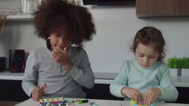 Portrait von schönen multiethnischen Kindern im Grundschulalter, die ein Entwicklungsspiel in Innenräumen spielen — Stockvideo