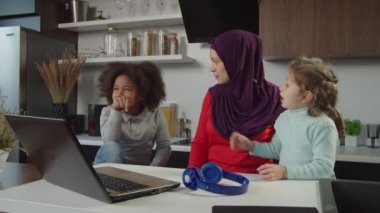 Güzel Arap tesettürlü anne ve iki sevimli ilköğretim çağı çok kültürlü kızı kapalı alanda kaynaşıyor.