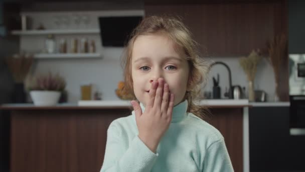 Portret van een schattig meisje van de kleuterschool dat een kus geeft en binnen lacht — Stockvideo