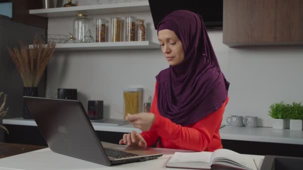 온라인 쇼핑을 하기 위해 노트북 과 신용 카드를 사용하는 히잡에 있는 꽤 현대적 인 중동 여성 — 비디오