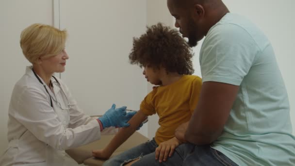 Adorável menino afro-americano em idade pré-escolar recebendo vacina no hospital — Vídeo de Stock