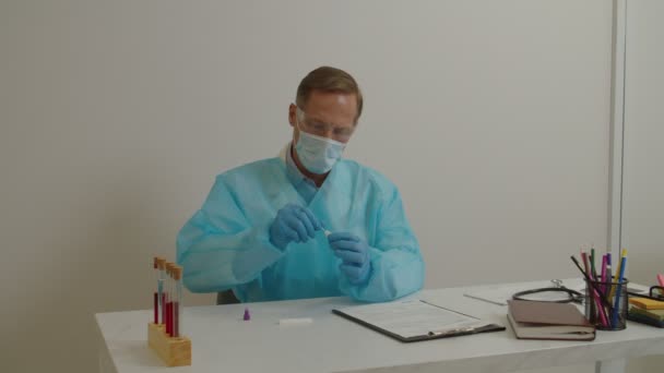 Korunaklı iş kıyafetleri bölümünde çalışan bir tıp çalışanı laboratuvarda koronavirüs hastalığı için PCR testi yapıyor.. — Stok video