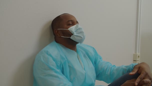 Portret wyczerpanego czarnego chirurga z zamkniętymi oczami odprężający po zabiegu chirurgicznym w szpitalu — Wideo stockowe