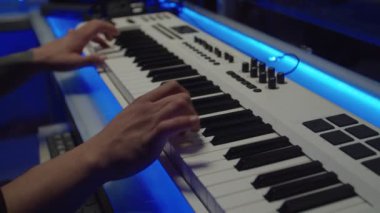 Klavye sentezleyicisi çalan söz yazarının elleri yakın plan müzik stüdyosunda yeni bir şarkı yaratıyor.