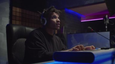 Profesyonel Afro-Amerikan erkek müzisyen dijital piyano çalıyor ve müzik stüdyosunda yeni bir şarkı yaratıyor.