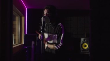 Çekici erkek hip hop sanatçısı mikrofona yeni hit şarkısını kaydediyor.
