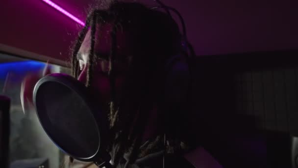Портрет вдохновлённого певца хип-хопа, исполняющего новую хитовую песню в студии звукозаписи — стоковое видео