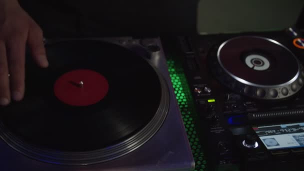 Close-up of dj hands mixing music, scratching vinyl record on turntable in nightclub — Stock Video