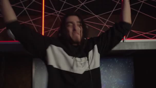 Portrait of energetic cool dj in headphones cheering up people during live set in nightclub — Stock Video