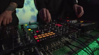Çok ırklı DJ 'ler, kulüpte canlı yayın sırasında ses karıştırıcı ve CD çalar kontrol ediyorlar.
