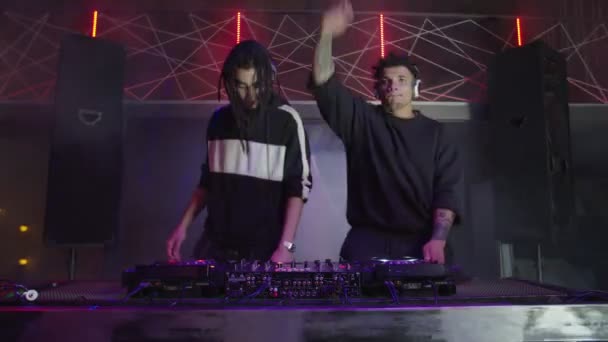 Energetikai hűvös multiracionális DJ-k modern disco house zenét játszanak és motiválják az embereket a nightclubban — Stock videók