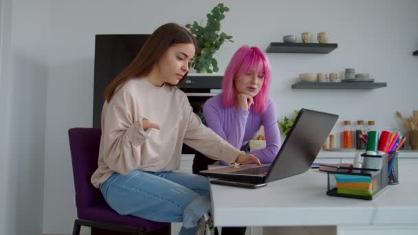 Vrouw met lichamelijke beperkingen en vrouwelijke vriend studeren met laptop indoor — Stockvideo