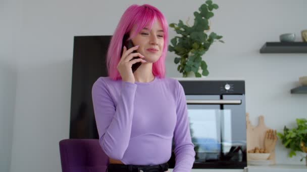 漂亮的粉色头发，带着牙套的女人在屋里用智能手机聊天 — 图库视频影像