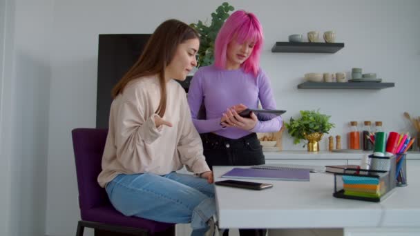 Pozytywne studentki z tabletem pracujące nad raportem uniwersyteckim — Wideo stockowe