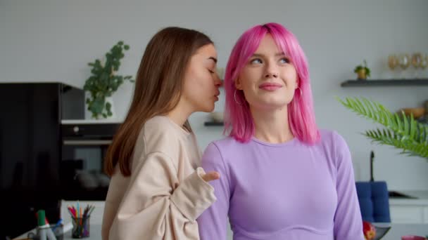 Schöne junge Frau mit körperlicher Behinderung flüstert ihrer Freundin Klatsch zu — Stockvideo