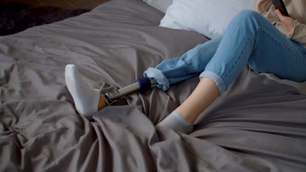 Jeune femme mignonne avec un handicap physique dans les écouteurs profitant de la musique sur le lit — Video