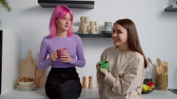 Alegre encantadora mujer compañeros de piso charlando sobre el café en la cocina en el dormitorio — Vídeo de stock