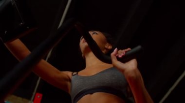 Egzersiz bisikletinde spor yapan Afrikalı bir kadının düşük açılı görüntüsü.