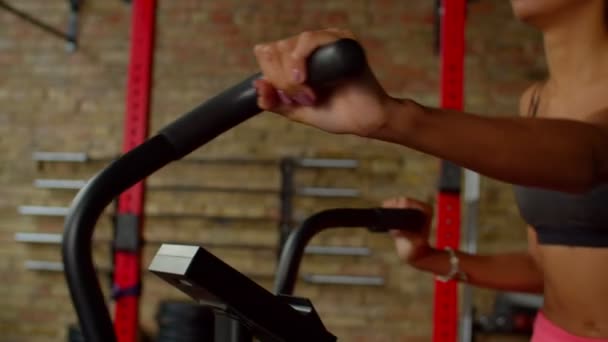 Gros plan des mains féminines sur le guidon de vélo d'appartement pendant l'entraînement — Video