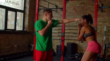 Formda Afro-Amerikan kadın boksör eğitimi. Koçla savunma taktikleri.