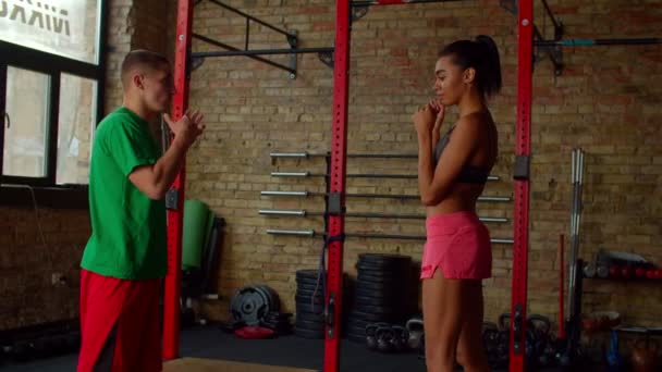 Professional male boxing coach with lovely black female athlete training at gym — Stock Video