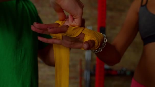 Close-up dari boxer perempuan bungkus tangan dengan bungkus pergelangan tangan sebelum sparring — Stok Video
