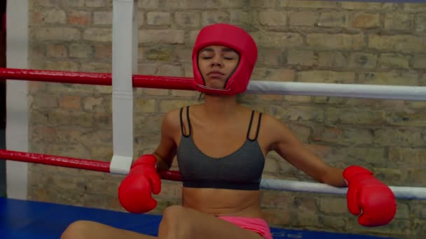 Uitgeputte sportieve Afrikaanse vrouw vechter ontspannen binnen boksring na training — Stockvideo