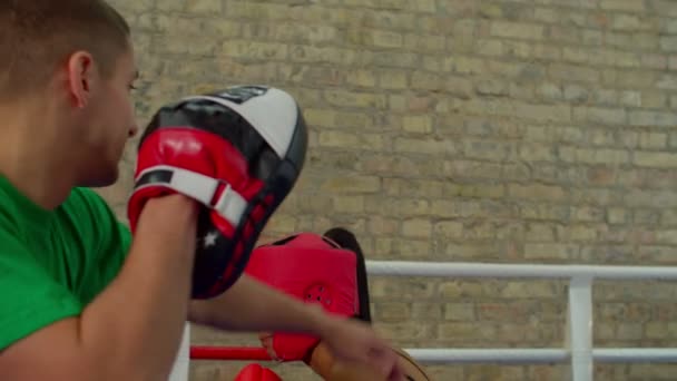 Мотивированная тренировка афроамериканской женщины-боксера с тренером внутри боксерского ринга — стоковое видео