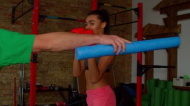 Aktif Afrikalı kadın boks eldivenli boksör antrenörle egzersiz yapıyor.