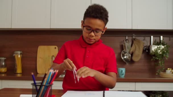 Smart cute school age African American boy drawing circle with divider compass — Stockvideo