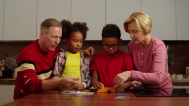 Dedeleri evde renk bulmacası oynayan heyecanlı çoklu etnik torunlar