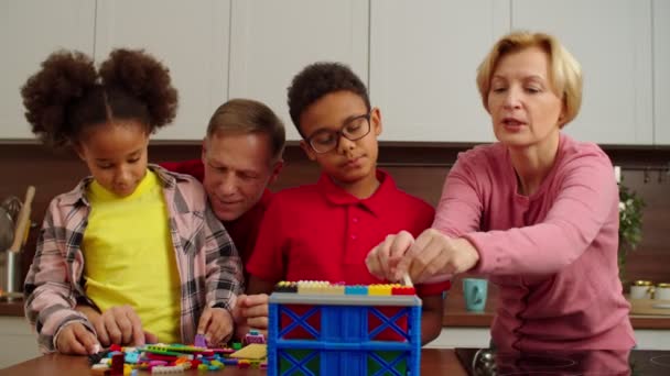 Happy multigenerational family with kids playing with toy constructor blocks — Stock Video