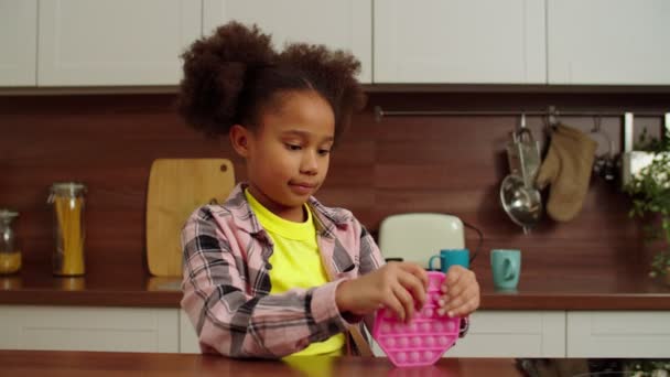 Cute school age African American girl playing with antistress sensory fidget toy — стоковое видео