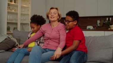 Neşeli ergenlik öncesi çoklu etnik çocuklar ve büyükanneleri evde eğleniyorlar.