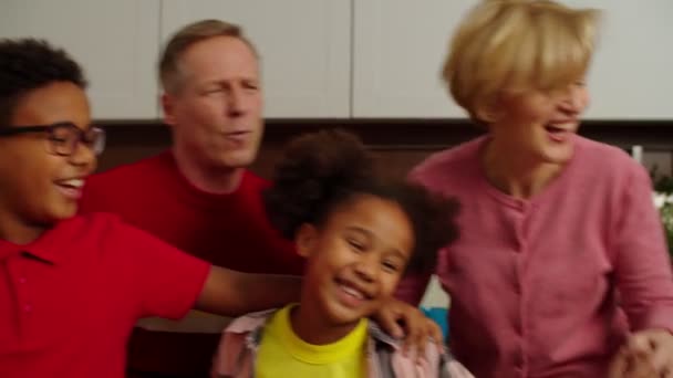 Portrét sjednocené multietnické multigenerační rodiny užívající si volného času v interiéru — Stock video