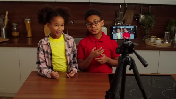 Positive adorable preadolescent black kids recording video for vlog indoors — ストック動画