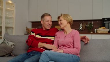 Gülümseyen okul çağındaki çok kültürlü çocuklar büyük anne ve babalarını kucaklıyor.