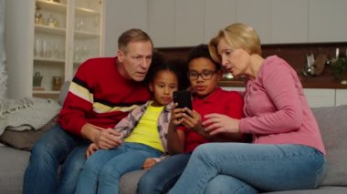 Dedeleri cep telefonuyla iletişim kuran çok kültürlü torunlar.